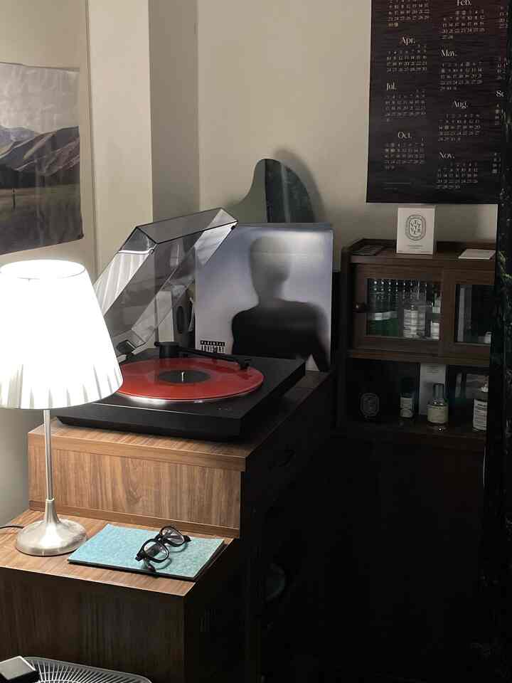 ブラウン系の木目調ミニ収納家具と赤いレコードがある落ち着いた雰囲気のインテリア