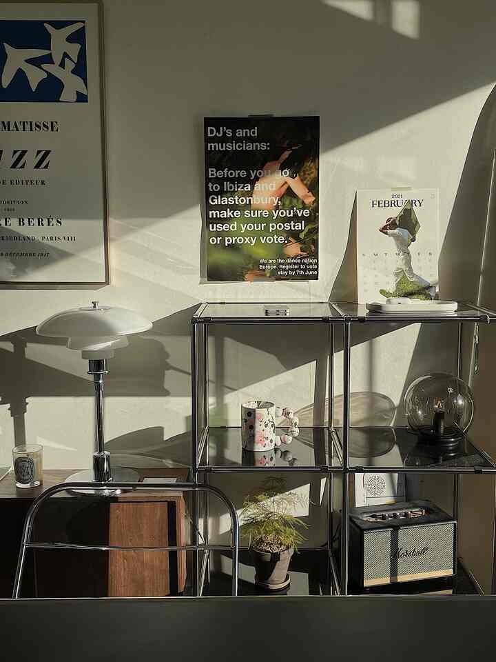 ブラウンとブラックの調和が取れたホームオフィス、ポスターと植物が配置されたモダンなインテリア