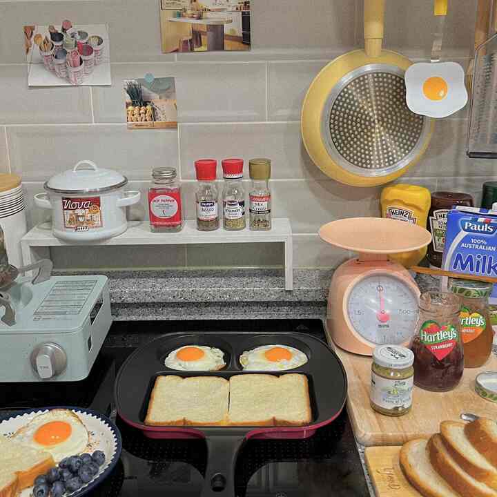 黄色と黒のトーンでまとめられたキッチン、フライパンで卵とトーストを調理している印象的な空間