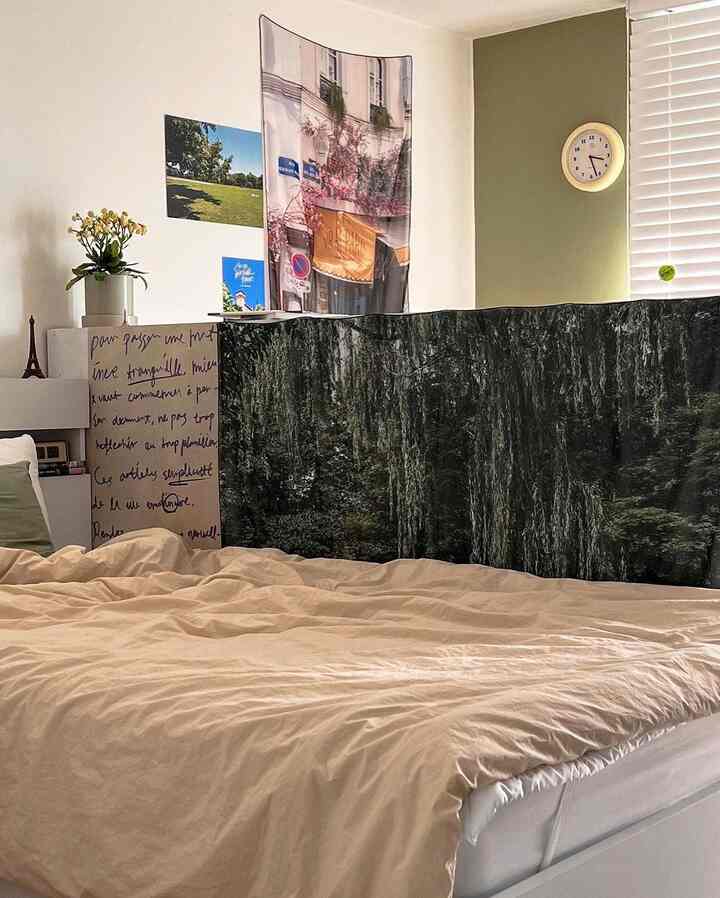 ナチュラルカラーの寝室、ベッドとデスク、間仕切りにポスターが配置された落ち着いた雰囲気のインテリア