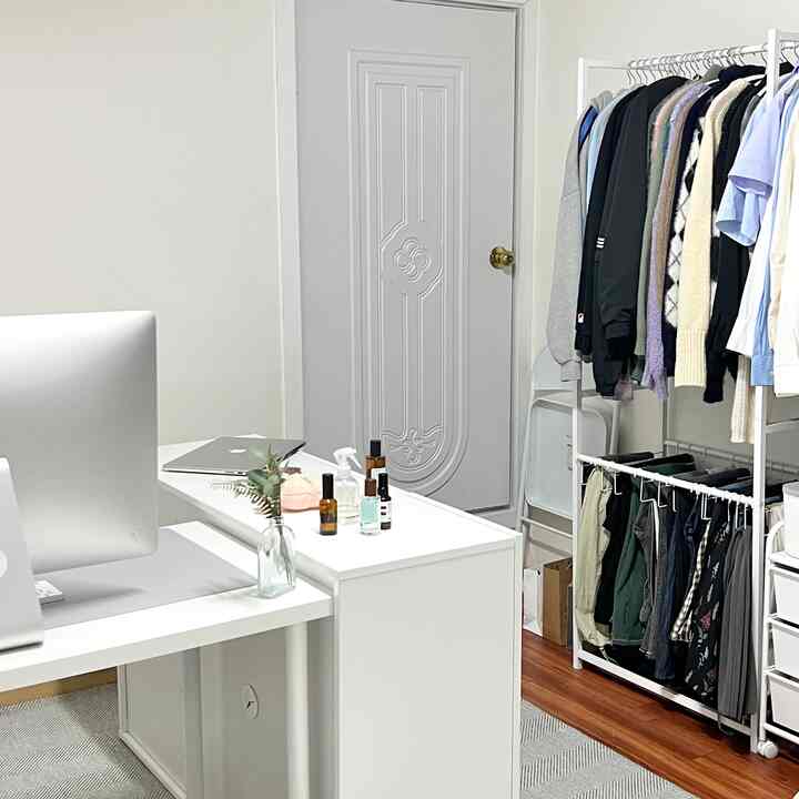 白を基調としたウォークインクローゼットとデスクが配置された清潔感のある作業・収納空間