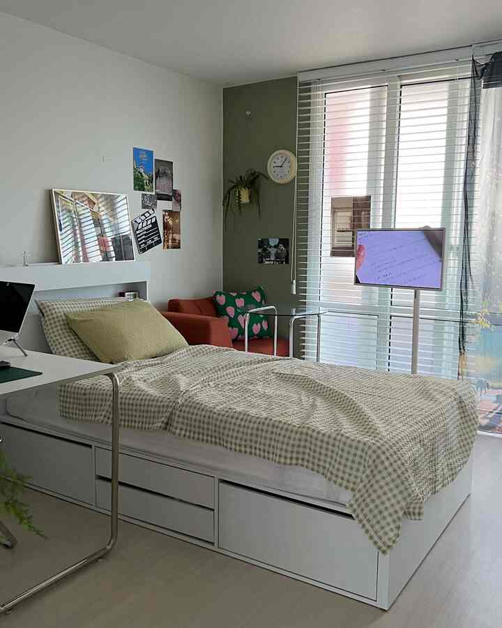 ホワイトとベージュの落ち着いた色調のコンパクトな寝室、収納付きシングルベッドとソファが配置されたシンプルモダンな印象的な空間