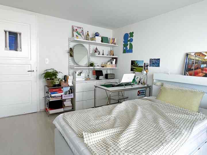 ホワイトトーンの寝室、シングルベッドとデスクが配置されたモダンで整った空間