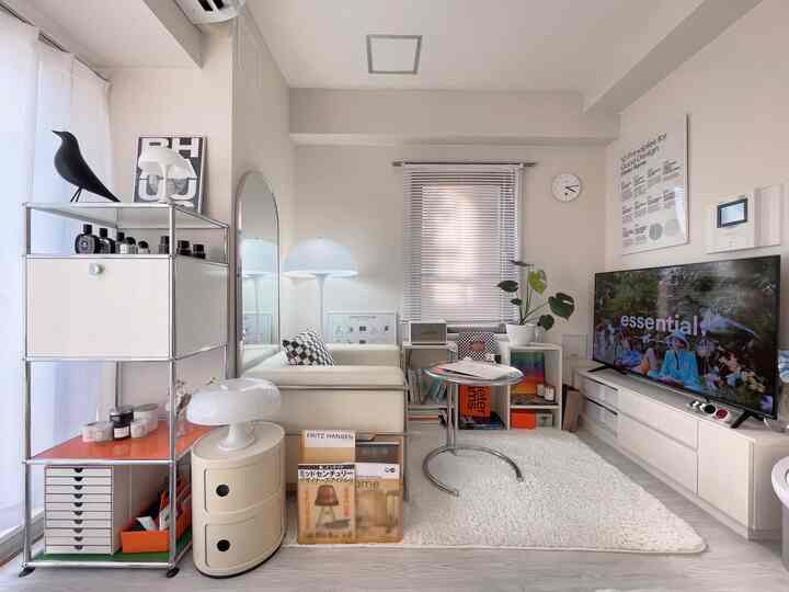 明るい白色のリビング、白いソファとラグ、テレビ台が配置されたシンプルモダンな雰囲気のインテリア