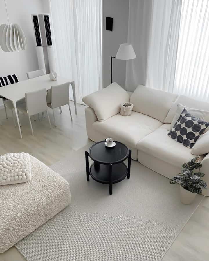 白と黒のトーンでまとめられたモジュールソファとダイニングテーブルが配置されたシンプルモダンなリビング