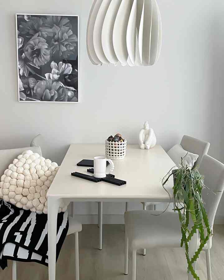 白を基調としたリビングダイニング、シンプルな四角テーブルとペンダントライトが配置された清潔感のあるインテリア