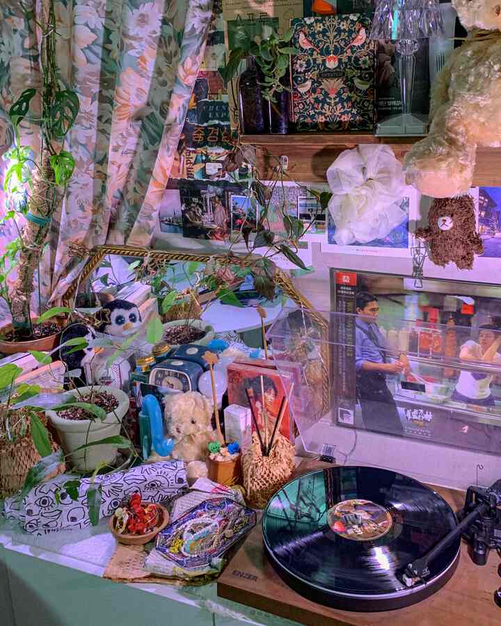 ヴィンテージと植物インテリアが調和するワンルーム、LPプレーヤーや多様な小物が配置された雰囲気のある空間