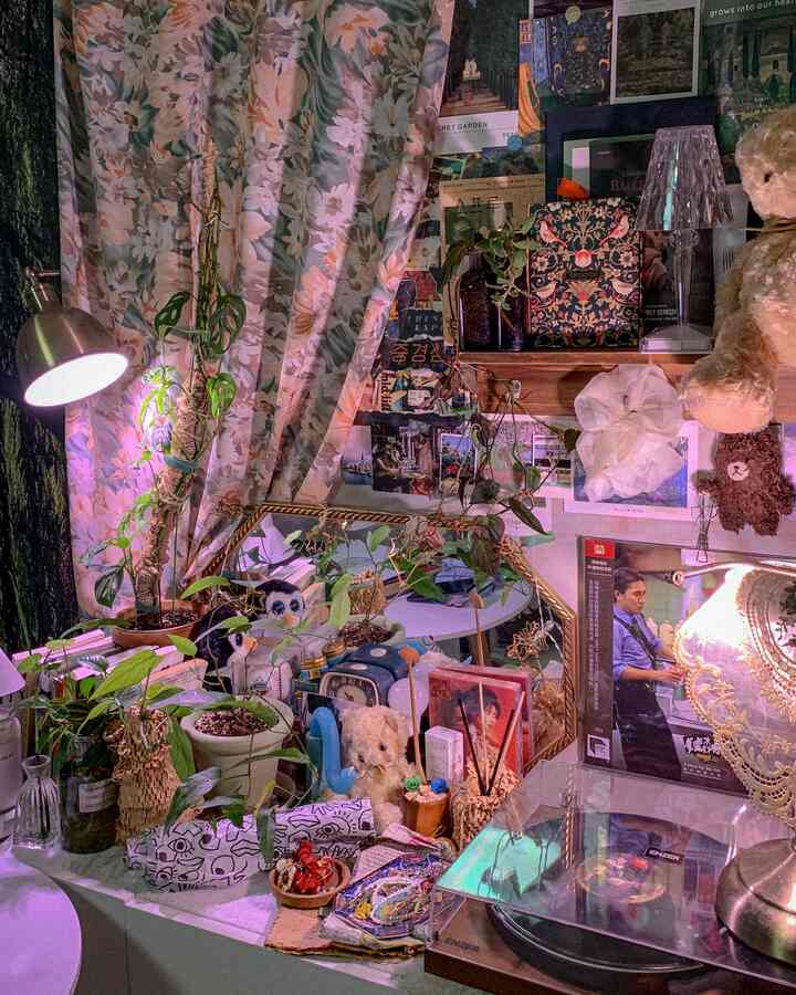 ヴィンテージ柄のカーテンと多彩なポスター、植物が調和した雰囲気のあるウォールデコ空間