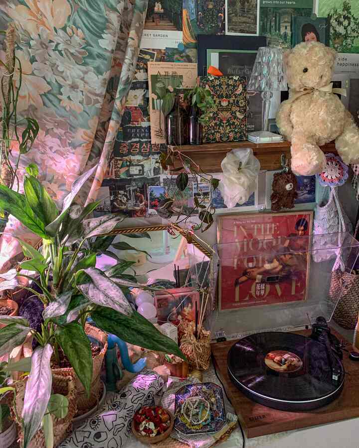 暖かいグリーンとヴィンテージ調のワンルーム、ポスターと植物が配置された雰囲気のある音楽スペース