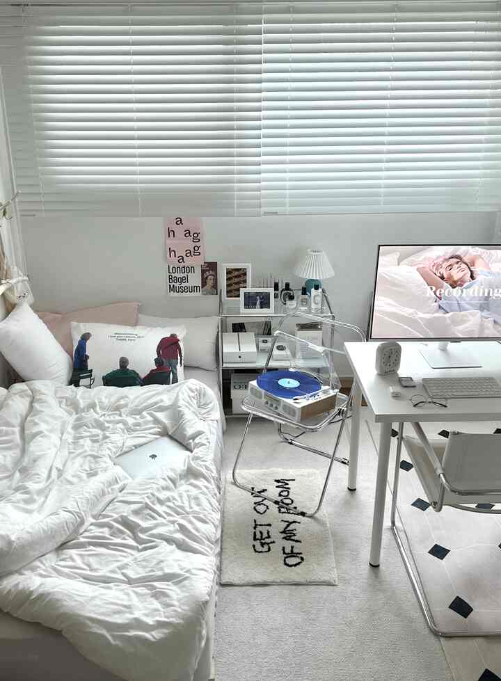 ホワイトトーンの寝室、白い寝具と透明な椅子、LPターンテーブル、デスクが配置された落ち着いた雰囲気のあるインテリア