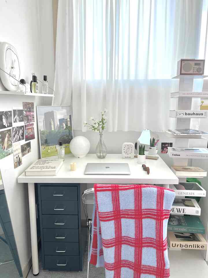 ホワイトとネイビーの色調のホームオフィス、机・引き出し・棚が整然と配置された明るく温かみのあるインテリア