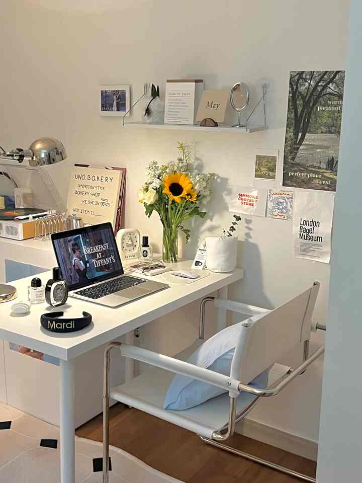 白と木目調の調和が美しいホームオフィス、机とアームチェア、花瓶、壁棚が配置された落ち着いた雰囲気のインテリア