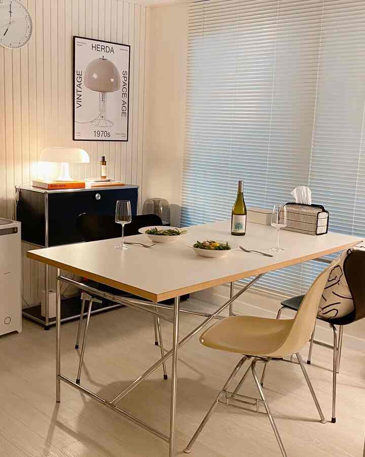 白とシルバーの色調のダイニングルーム、リチャードランパートアイアマン2テーブルと様々なチェアが配置されたモダンな空間