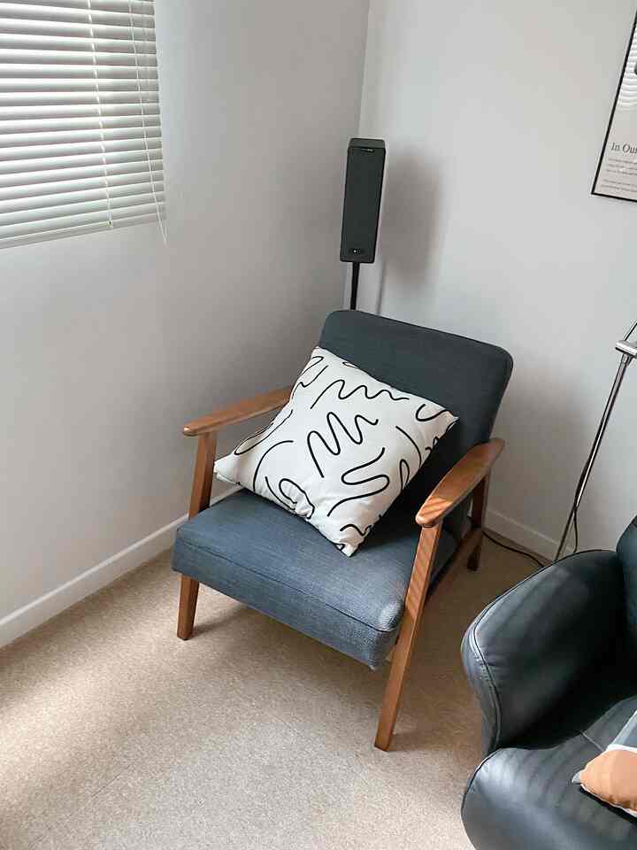 ウッドトーンとダークグレーのアームチェアが置かれたシンプルなキッチンコーナーのインテリア