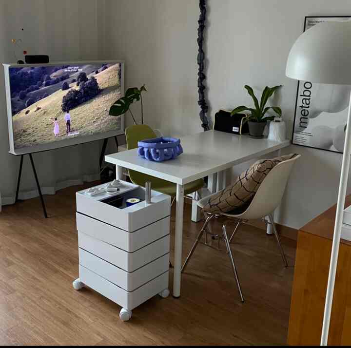 ホワイトとウッドトーンのリビング、イケアのテーブルとトロリー、テレビ、植物、照明が配置された印象的な空間