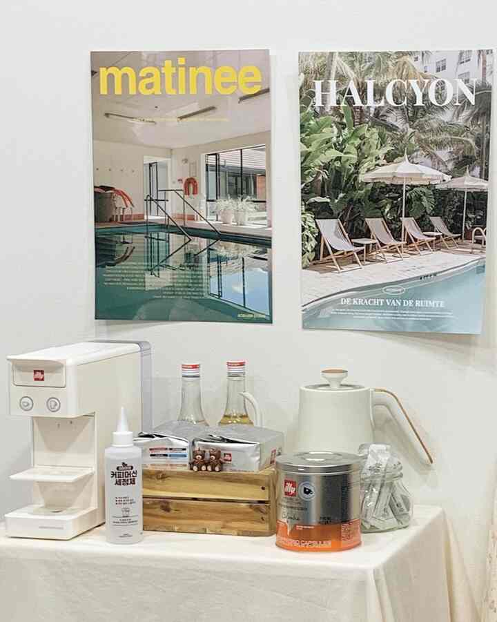 白とベージュの色調のホームカフェ空間、コーヒーマシンやカプセル、テーブルクロスが配置された温かみのあるインテリア