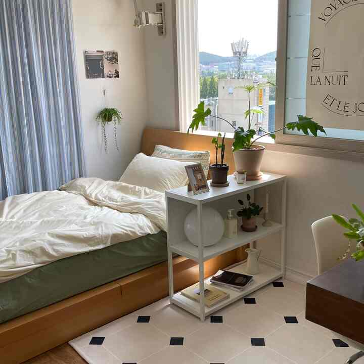 ホワイトと木目調の調和が取れた小さな寝室、シングルベッドと本棚、木製のデスクが配置された落ち着いた空間