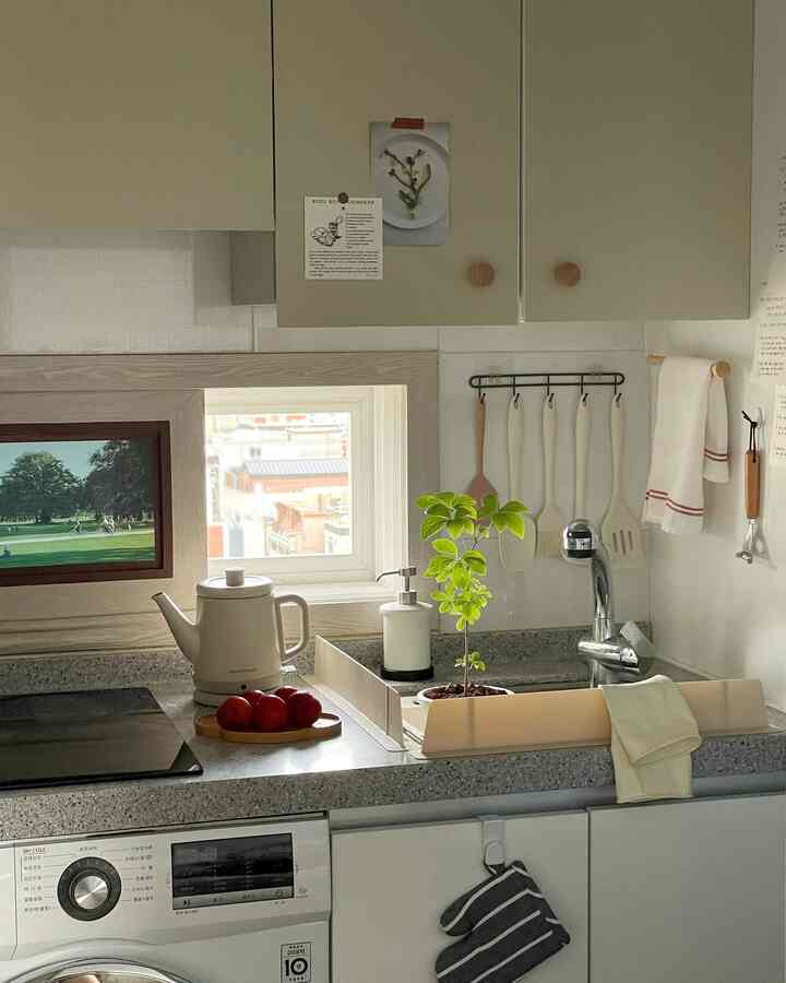 ナチュラルな色調の小さなキッチン、ベージュの収納と洗練された調理器具が配置された落ち着いた空間