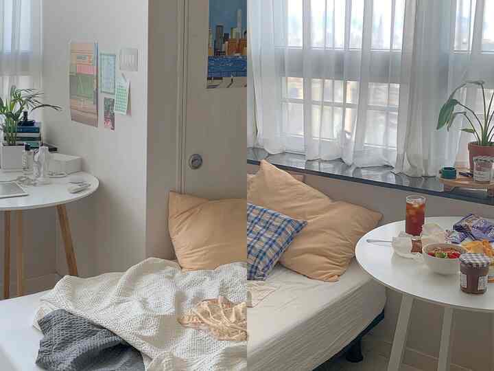 ホワイトトーンのワンルーム寝室、丸いホワイトのダイニングテーブルと枕、シフォンカーテンが配置された自然でモダンな雰囲気のインテリア