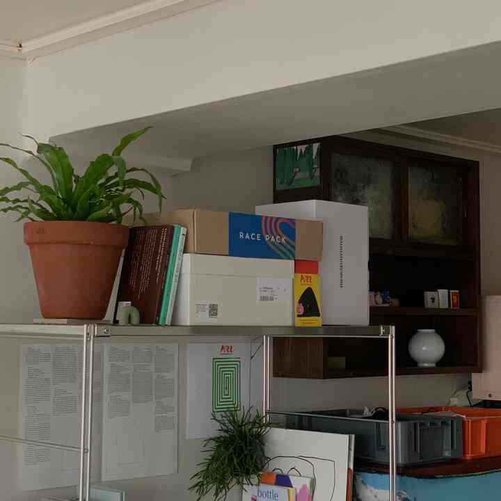 ナチュラルな色調のリビング、鉄製と木製の棚、テラコッタ鉢と収納箱が調和した落ち着いた雰囲気のインテリア