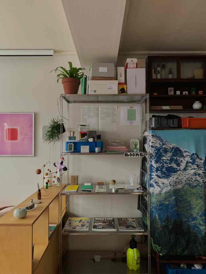 白い背景に金属製の棚と様々なオブジェが配置された雰囲気のある整った空間