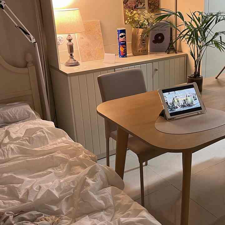 ナチュラルカラーとホワイトトーンのワンルーム寝室、ダイニングテーブルと椅子が配置された落ち着いた空間