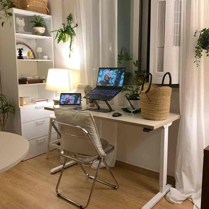 ナチュラルな色調のホームオフィス、スタンディングデスクとラップトップスタンドが配置された整った作業空間