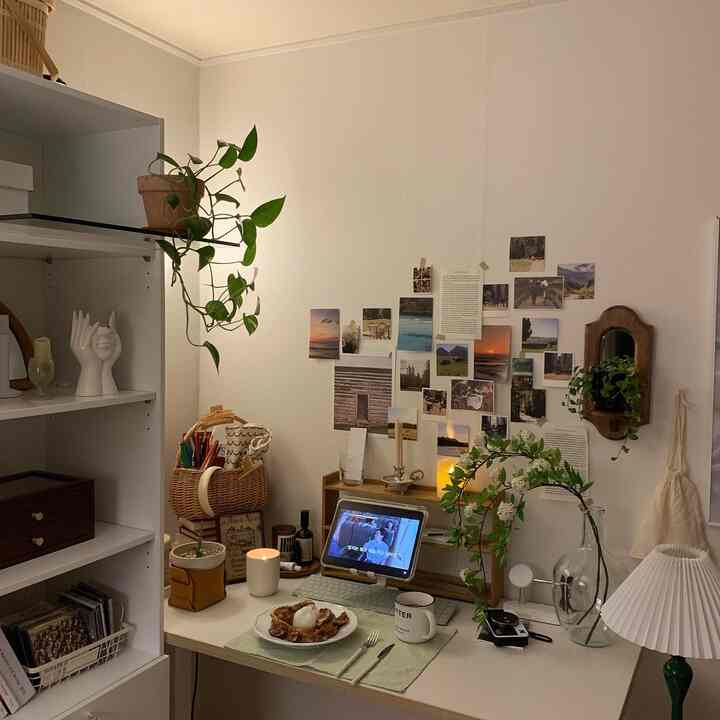 暖かいベージュとホワイトの色調のホームオフィス、植物と壁のデコレーションが配置された雰囲気あるデスクインテリア