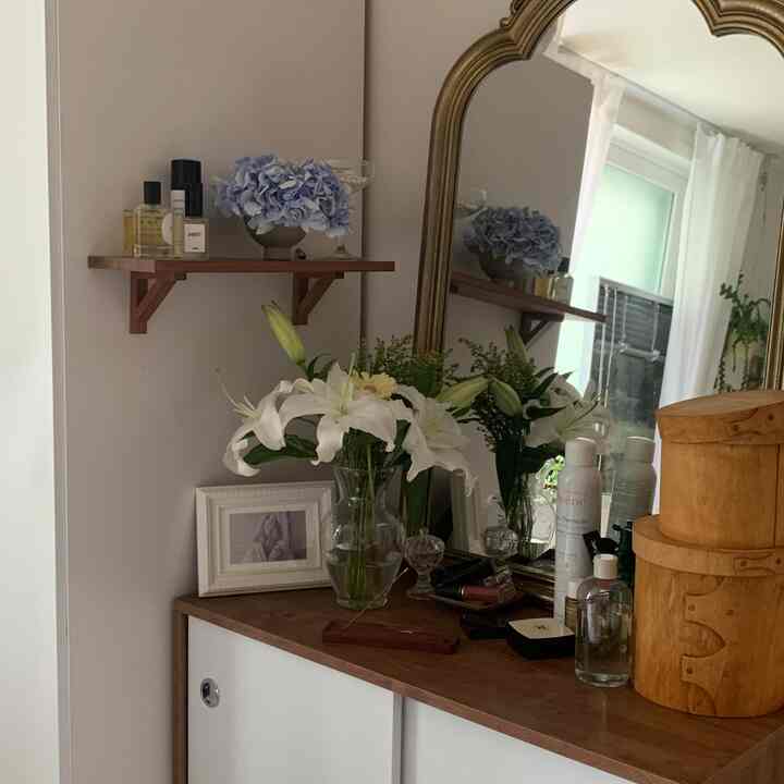 自然な木目調と白を基調とした化粧台と鏡が配置された居心地の良い寝室空間