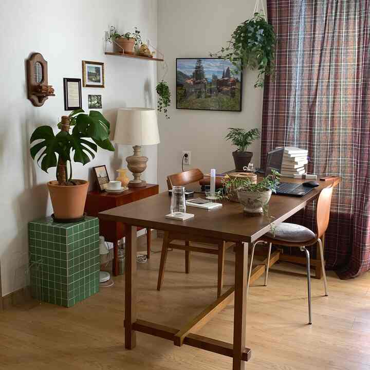 木目調の床と家具、植物が調和したリビングのホームオフィス、暖かく落ち着いた雰囲気のインテリア