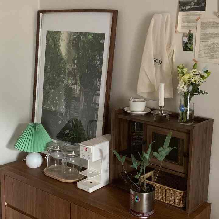 ブラウンの木目調家具と白い壁、コーヒーマシンやヴィンテージの小物が調和したナチュラルなおうちカフェの空間