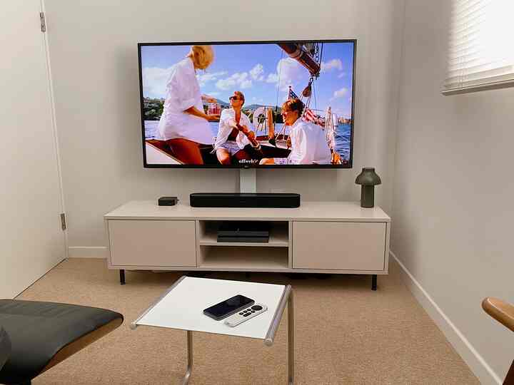 ホワイトとベージュの色調のリビング、中央にテレビとソノスサウンドバーが配置されたミニマルでコンパクトなホームシネマ空間