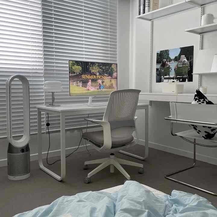 ホワイトとグレーのトーンでまとめられたコンパクトなホームオフィス、机とオフィスチェアが配置されたモダンで整然としたインテリア