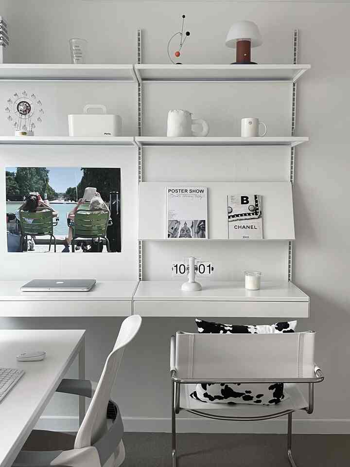 白を基調としたホームオフィス、白いデスクとオフィスチェア、整然とした棚が配置されたシンプルな作業空間