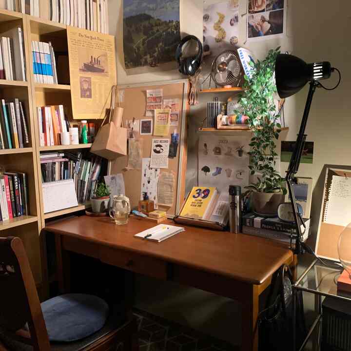 温かみのある木目調の書斎、机と本棚、植物が配置された落ち着いた個人作業空間