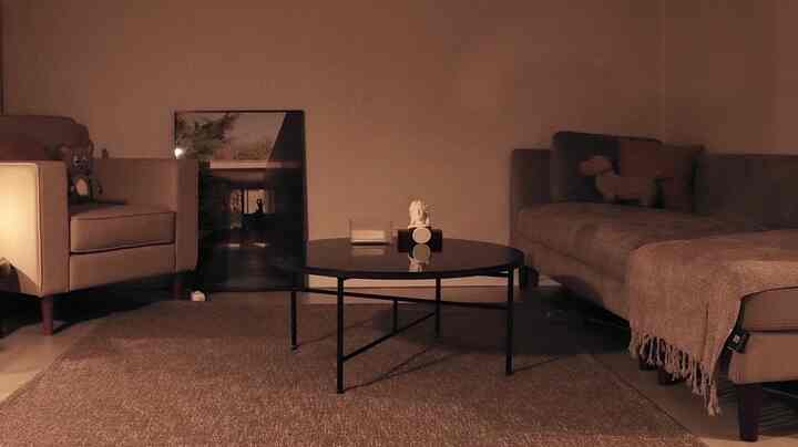 暖かみのあるナチュラルブラウン調のリビング、一人掛けと三人掛けのソファと丸いコーヒーテーブルが調和した雰囲気のあるインテリア