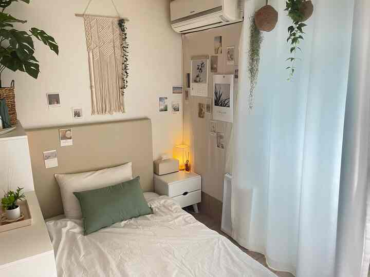 柔らかなウッドトーンとナチュラルな装飾が調和する寝室、シンプルなベッドと遮光カーテンが落ち着いた雰囲気を演出