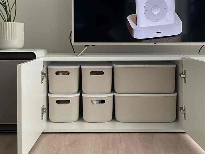 白を基調とした寝室のキャビネットに整理されたリビングボックスが並ぶ、清潔感のある実用的な空間