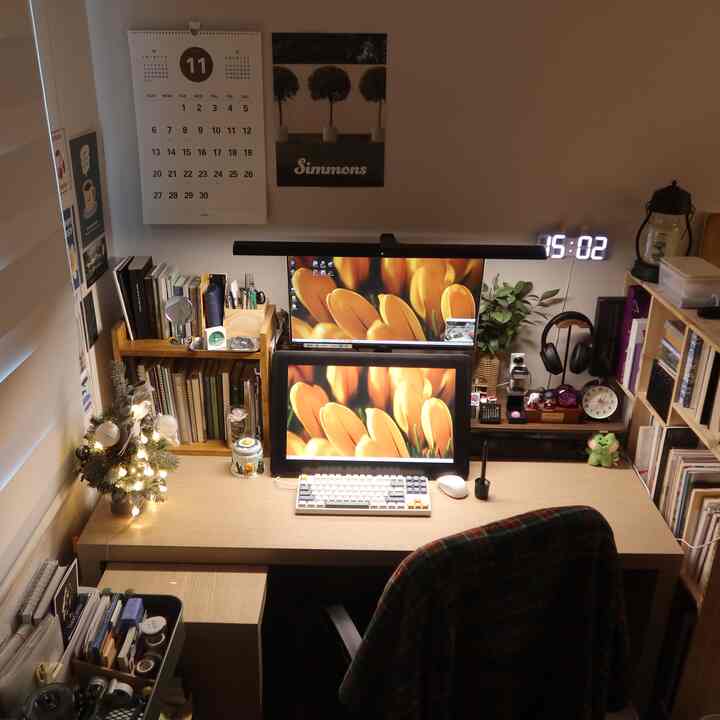 ナチュラルな木目調のコンパクトなホームオフィス、デュアルモニターとデスク、落ち着いたデスクインテリアが印象的な作業空間