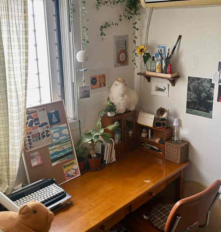 温かみのある木目調とナチュラルな植物が配置された一人暮らし向けホームオフィスのデスクスペース