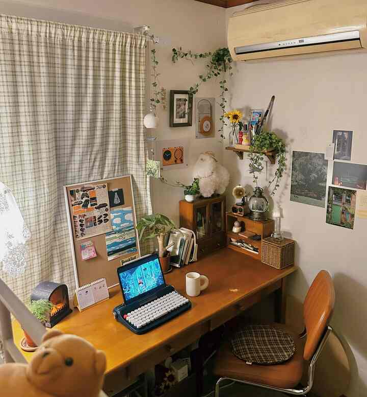 温かみのあるウッドトーンとナチュラルな色調の書斎空間、壁の装飾と植物が落ち着いた雰囲気を演出