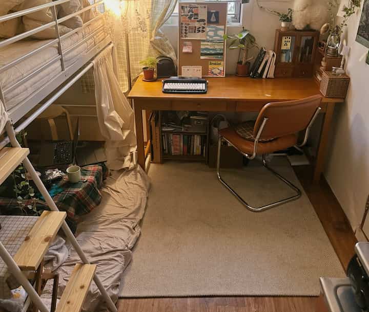 ベージュと木目調が主体の4.5畳のホームオフィス、二段ベッドと植物が配置され温かみのあるインテリア