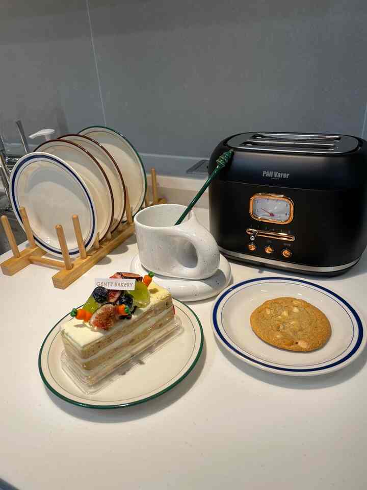 白と木目調が調和したキッチンテーブル、皿とマグカップ、トースターが配置されたおうちカフェの印象的な空間