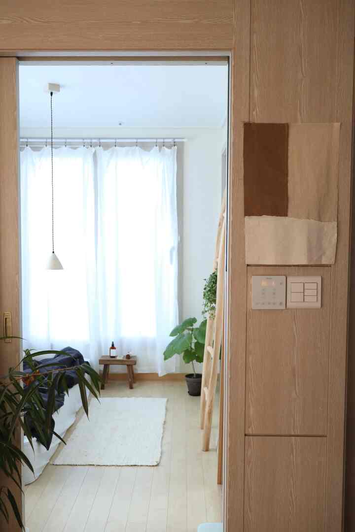 白と木目調の寝室、自然素材と植物が配置された雰囲気のあるインテリア