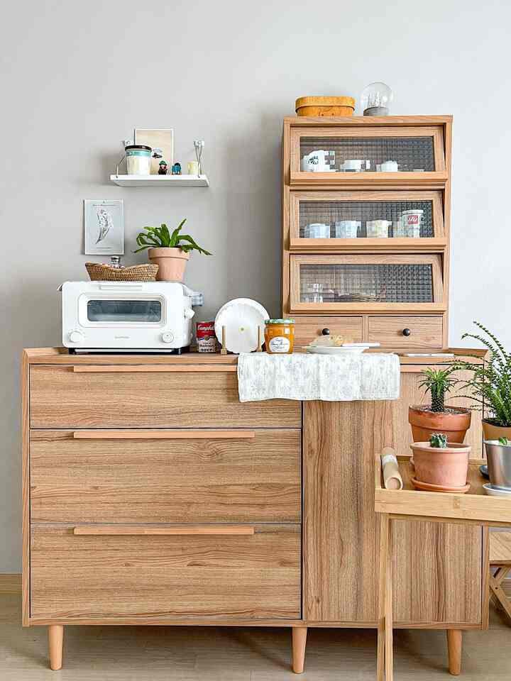 ブラウンの木目調とホワイトのアクセントが調和したナチュラルなキッチン収納が配置された雰囲気のあるインテリア