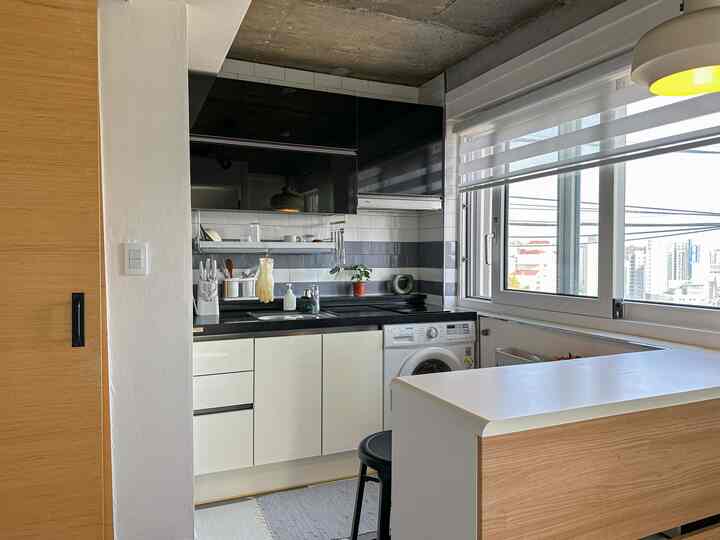 ホワイト、ブラック、ウッドトーンが調和したコンパクトなキッチン、モダンな雰囲気のキッチン