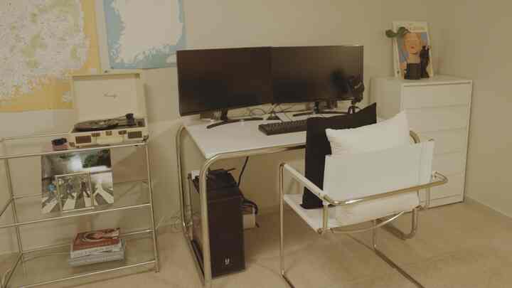 モダンな白とシルバーのトーンのホームオフィス、デュアルモニターとミニマルな家具配置で整った作業空間