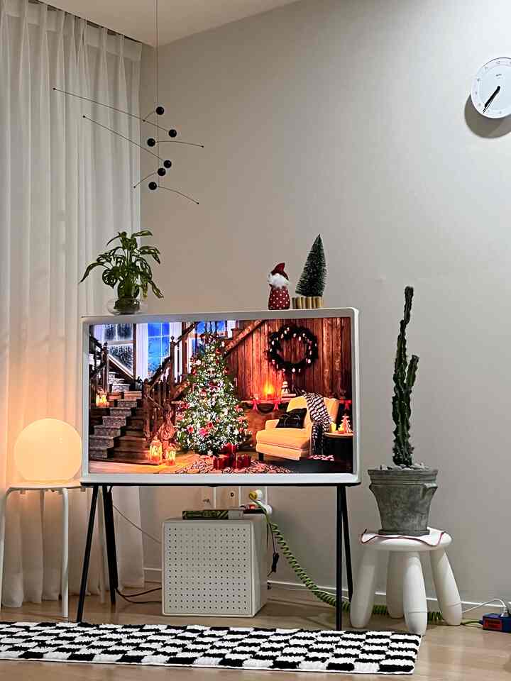 白とナチュラルカラーのリビング、テレビ台や植物、スツールが配置されたミニマルでシンプルなインテリア