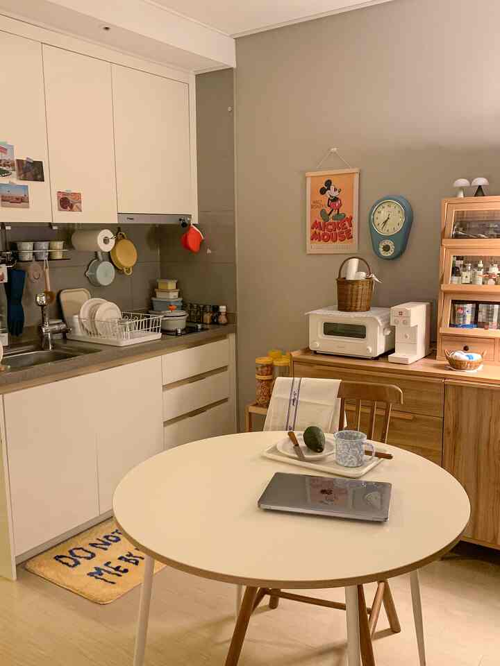 白と木目調が調和したキッチンとダイニングルーム、シンプルでミニマルな雰囲気のインテリア