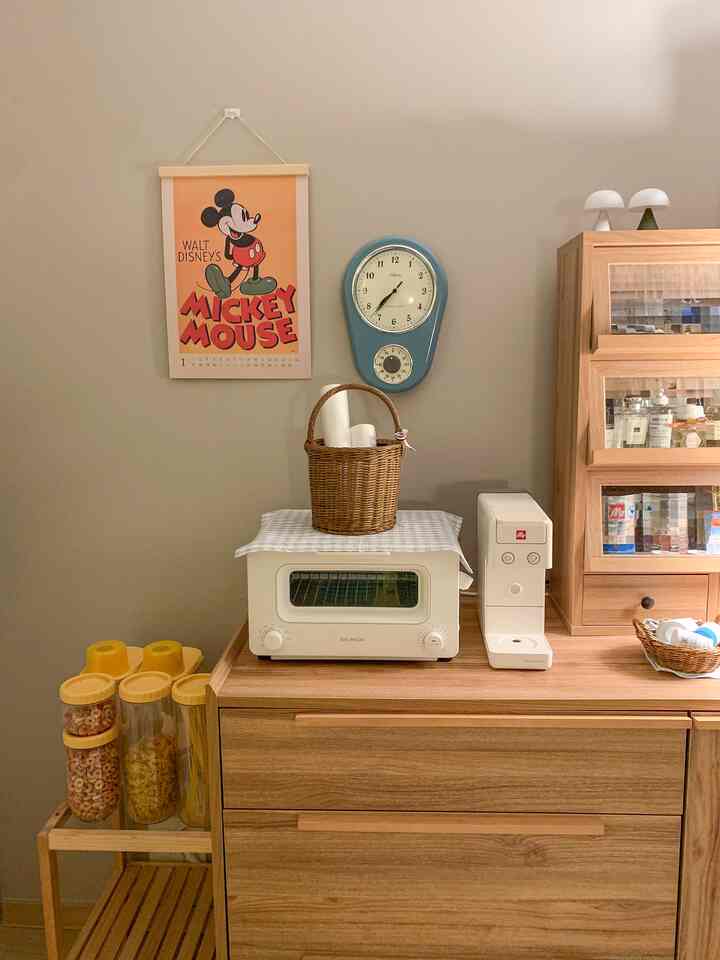 グレーの壁と木目調コンソールが調和したおうちカフェ空間。バルミューダトースター、イリーコーヒーマシン、ヴィンテージの壁時計が配置された雰囲気のあるインテリア